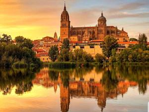 a view of a city with a reflection in the water at Apartamento Norte Comfort in Salamanca