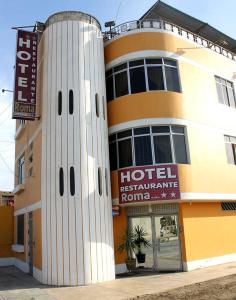 un bâtiment d'hôtel avec un panneau d'hôtel devant lui dans l'établissement Hotel y Restaurante Roma, à Ica