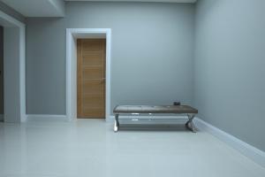a bed in a white room with a door at Glass Island Ballycastle in Ballycastle