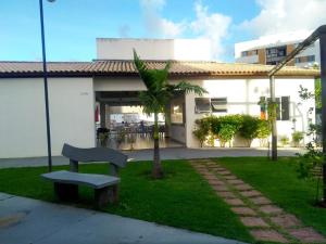 a bench sitting in the grass in front of a building at Condominio Port. da cidade Aracaju in Aracaju
