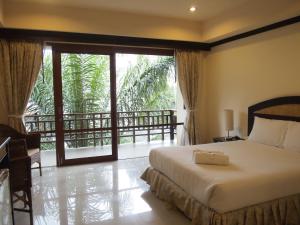 a bedroom with a bed and a window with a balcony at Summer Inn in Lamai