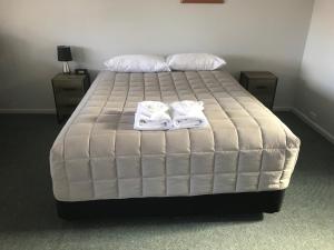 una camera da letto con un letto e due asciugamani di Kootingal Landview Motel a Kootingal