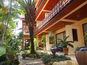 un patio con palmeras y un edificio en Summer Inn, en Lamai