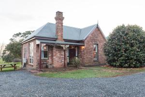 una casa de ladrillo con una chimenea encima en Killynaught Spa Cottages, en Boat Harbour