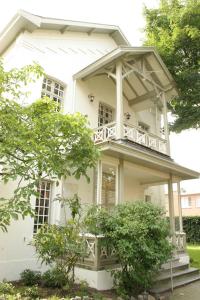 a white house with a balcony on top of it at B&B Villa Acacia in Kapellen