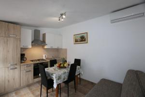 a kitchen and dining room with a table and chairs at House Car Mirko in Šilo