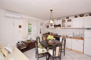 a kitchen and dining room with a table and chairs at House Green Paradise in Vrpolje