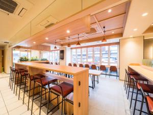 Super Hotel Hirosaki في هيروساكي: غرفة طعام كبيرة مع طاولة وكراسي طويلة