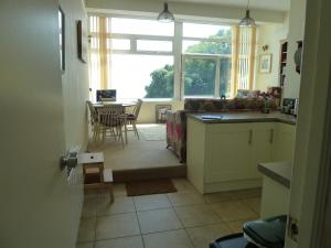 een keuken met een raam en een tafel met stoelen bij 2A Redcliffe Apartment in Bishopston