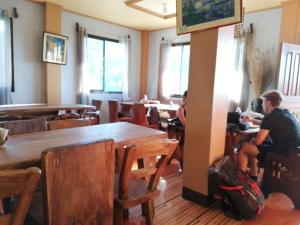 a restaurant with wooden tables and people sitting at tables at 7th Heaven Lodge and Cafe in Banaue +22 photos
