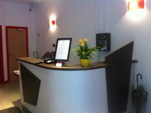 a reception desk with a laptop computer on top of it at Hotel Bristol Metz Centre Gare in Metz