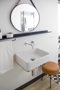 W łazience znajduje się biała umywalka i lustro. w obiekcie Appartamento 14 10 w mieście Marcigliana