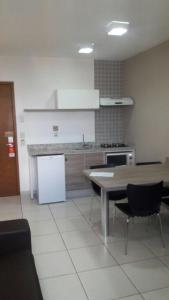 cocina con mesa y nevera en Apartamento no Riviera Park, en Caldas Novas