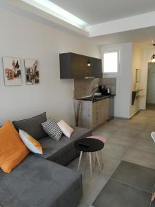a living room with a couch and a kitchen at City Center Studios in Kavála