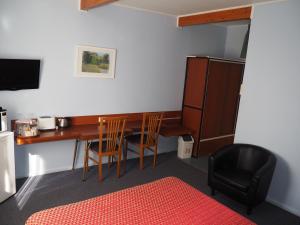 a room with a table and chairs and a desk at Cudgegong Valley Motel in Mudgee