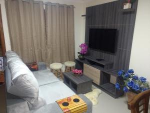 Residencial Correa Pereira في كانيلا: غرفة معيشة مع أريكة وتلفزيون بشاشة مسطحة