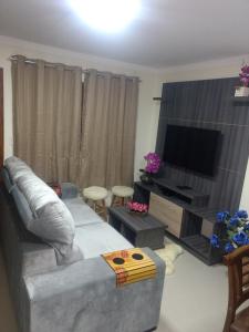 sala de estar con sofá y TV de pantalla plana en Residencial Correa Pereira, en Canela