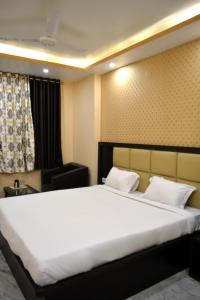 a bedroom with a large white bed in a room at Olive suites in Patna