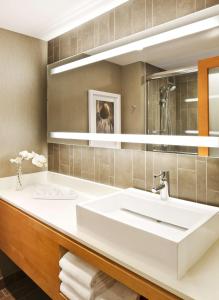 
a bathroom with a sink, mirror, and bathtub at Hyatt Regency Long Beach in Long Beach
