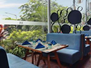 a table with two blue chairs and a wooden table with at Mercure Jakarta Simatupang in Jakarta