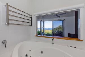 a white bath tub in a bathroom with a window at Aquatic Visions in Margaret River Town +28 photos
