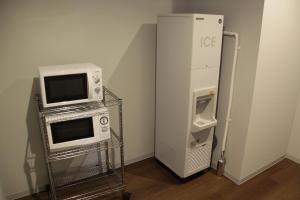 Cette chambre comprend un four micro-ondes, un réfrigérateur et un four micro-ondes. dans l'établissement Takamatsu Century Hotel, à Takamatsu