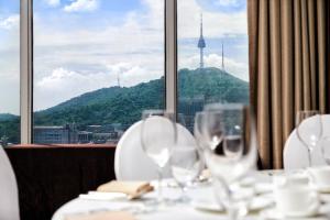 a table with wine glasses in front of a window at Hotel President in Seoul