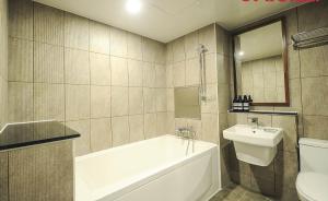 a bathroom with a tub and a sink and a toilet at Hotel Louis in Busan +29 photos