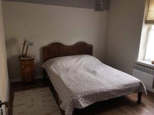a bedroom with a bed with a white comforter and a window at Kreutzwaldi Apartement in Võru