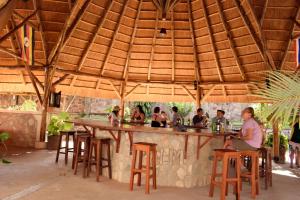 um grupo de pessoas sentadas num bar em Entebbe Palm Hotel em Entebbe