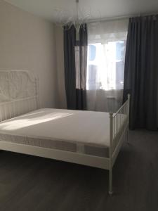 un letto bianco in una camera da letto con finestra di Счастливые квартиры на Зелинского 5 a Tyumen