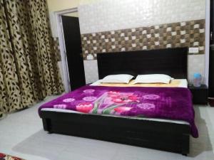 a bedroom with a bed with a purple blanket at Vidya Guest House in Katra