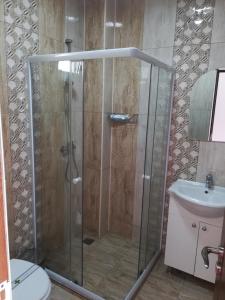 una ducha con puerta de cristal en un baño en Casa Gogu, en Mamaia Nord – Năvodari