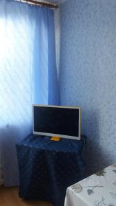 a flat screen tv sitting on a table in a bedroom at Apartments at the church alley in Daugavpils