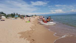 a group of people on a beach with a boat at Bely Parus in Bosteri
