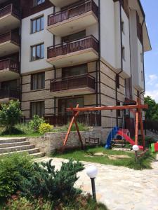 an apartment building with a playground in front of it at Apartments Four Leaf Clover Bansko to rent in Bansko
