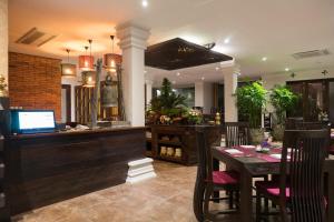a dining room with a table and a bar at Shinnabhura Historic Boutique Hotel in Phitsanulok