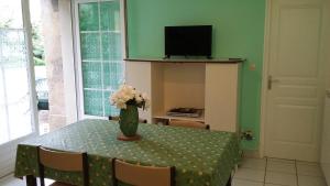 a dining room table with a vase of flowers on it at Gites Domaine d'En Baleux in Labruguière