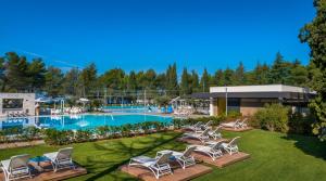 a resort with a swimming pool and lounge chairs at Maistra Camping Valkanela Mobile homes in Funtana