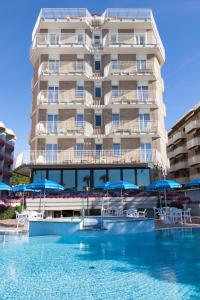 a hotel with a swimming pool in front of a building at Regent's Hotel in Lido di Jesolo