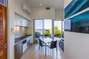a kitchen with a table and chairs and a large window at Aquatic Visions Studio Apartments in Margaret River Town