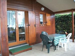 a table and chairs on the porch of a house at Camping Routes du Monde ATC Veyrier du Lac - Annecy in Veyrier-du-Lac