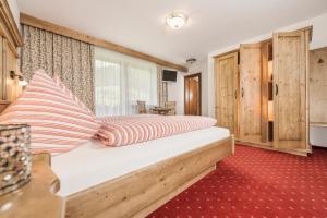 a bedroom with a bed with striped pillows on it at Haus Christine in Ried im Zillertal