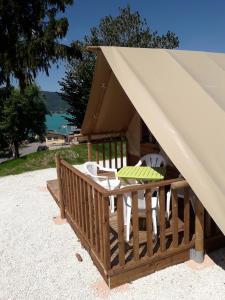 a tent with a table and chairs on a beach at Camping Routes du Monde ATC Veyrier du Lac - Annecy in Veyrier-du-Lac