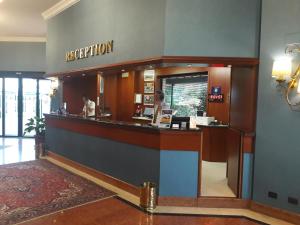 a reception area of a hotel with a woman at a counter at Hotel Motel Luna in Segrate