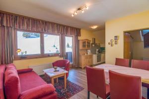 a living room with a red couch and a table at Appartementhaus Turracher Höhe in Turracher Hohe