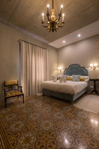 a bedroom with a bed and a chandelier and a chair at Sally Port Suites in Valletta