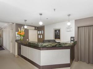 a lobby with a reception counter with a vase of flowers at Sunbird Beach Resort in Gold Coast