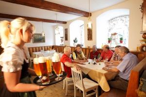 eine Gruppe von Menschen, die mit Bier am Tisch sitzen in der Unterkunft Bärnsteinhof - Gasthof mit Herz in Aigen im Mühlkreis