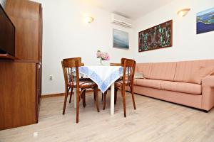 a living room with a table and chairs and a couch at Filipi Apartment in Sali